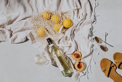 透明玻璃瓶，白色织物上有黄色圆形水果
